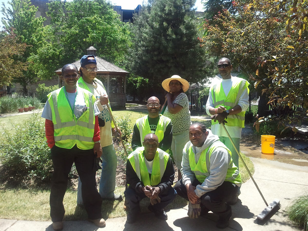 The Civic Community Works work crew poses for a team photo after finishing a project that turned a neighborhood eyesore into a community garden.