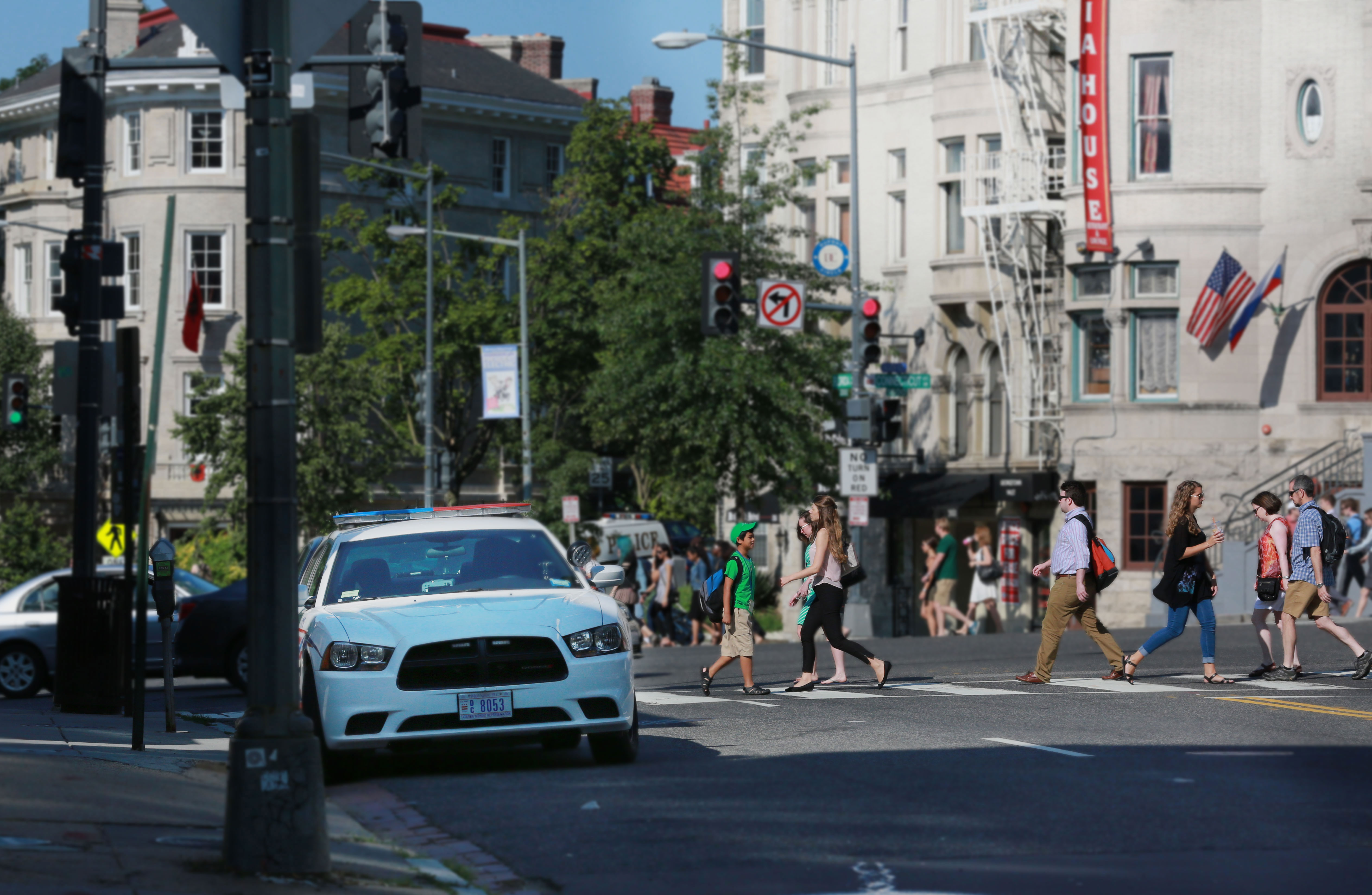 image of busy DC street with pedestrians and police car